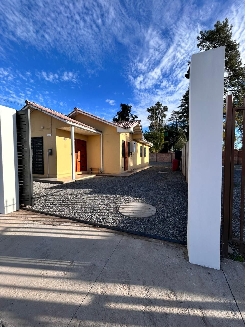 A residential building with a gravel driveway and a clear sky.