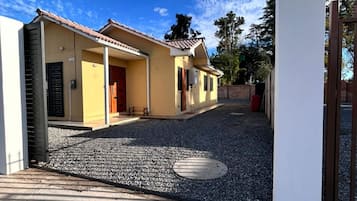 A residential building with a gravel driveway and a clear sky.