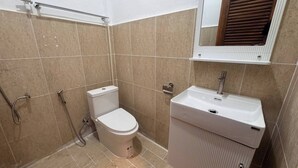 Een badkamer met toilet, wastafel en douche.