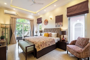 A bedroom with a bed, bedside tables, a chair, a desk, and a window with curtains. - Staymaster Una 4BR Villa (Assagao)