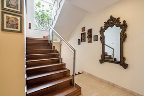 A wooden staircase with a handrail, leading to an upper floor. - Staymaster Una 4BR Villa (Assagao)