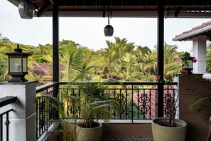 A balcony with a view of tropical vegetation, a hanging light fixture, and a potted plant. - Staymaster Una 4BR Villa (Assagao)