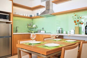Eine moderne Küche mit Essplatz für zwei Personen, einer Mikrowelle und einem Kühlschrank.