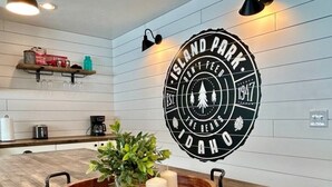 Una cocina con una isla de madera, un letrero en la pared y un estante con utensilios de cocina.