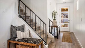 A staircase with a black railing, a bench with patterned cushions, and a rug on the floor. - Skyline 1742, Private Spa, Fire Pit, Community Amenities! (Washington)