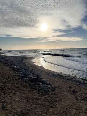 A beach with a curved shoreline, waves, and a clear sky. - Lovely holiday home near beach and nature (Vejby)