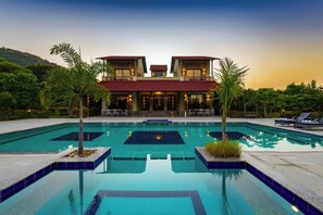 Un hôtel de deux étages doté d’une piscine, d’un espace extérieur aménagé et offrant une vue sur la verdure environnante.