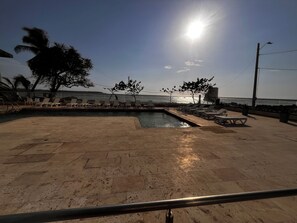 A pool area with lounge chairs and a view of the sea. - Palmetto Sunset Laguito 3-Bedroom Oceanfront (Cartagena)