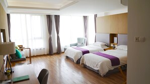 A hotel room with two beds, a desk, a chair, a lamp, and a window with curtains. - PengLai Mahota Town (Yantai)