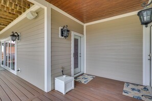 A covered porch with a wooden ceiling, a white exterior wall, and a door with a glass panel. - Near Cape Fear River! Relaxing Getaway w/ Views (Wilmington)