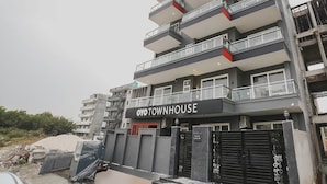 A multi-story building with balconies, a sign reading 'OYO TOWNHOUSE,' and a gated entrance. - Townhouse Sector 46 Gurgaon Near Appu Ghar (Gurugram)