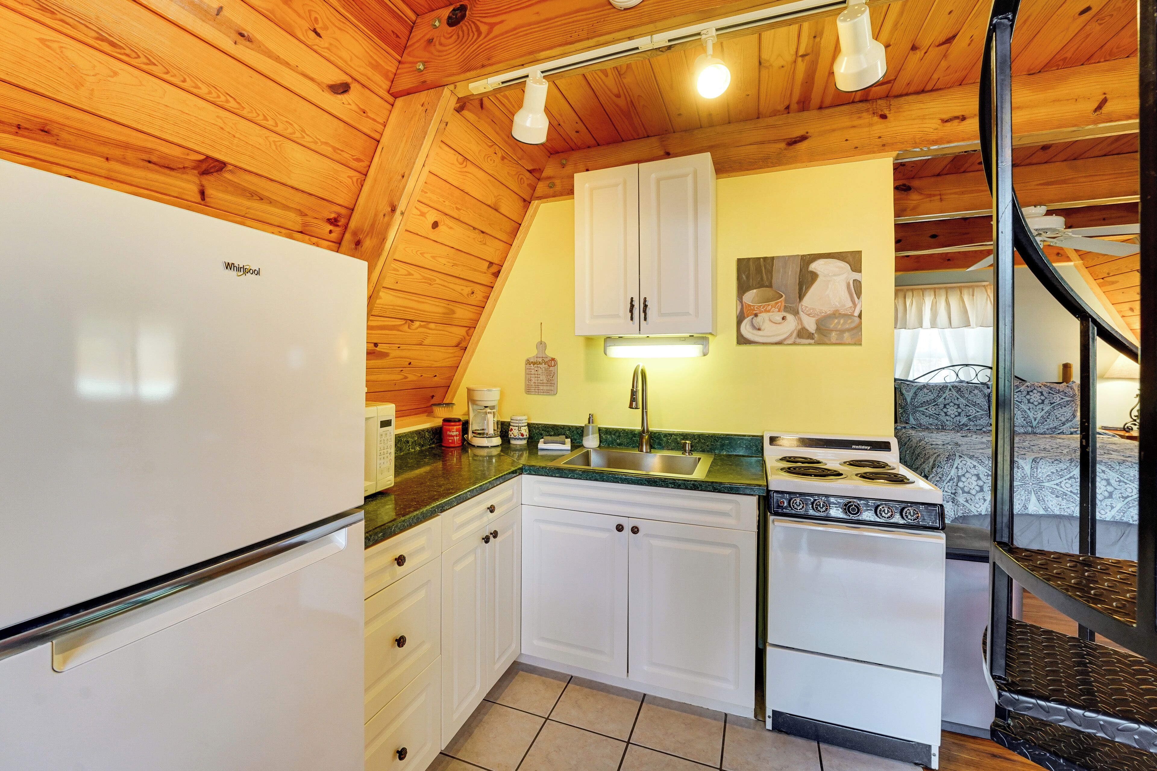 A kitchen with white cabinets, a stove, and a refrigerator.