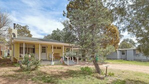 A yellow house with a porch, surrounded by trees and a fenced yard. - Payson Pines & Porch Vibes: Cool High Country Base (Payson)