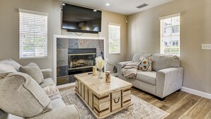 Una sala de estar con chimenea, televisor y dos sofás.