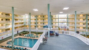 A multi-story hotel with a central swimming pool, balconies, and a covered seating area. - Walk to Beach! Family-Friendly Hilton Head Condo (Hilton Head Island)