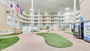 A multi-level hotel atrium with a central walkway, indoor plants, and vending machines. - Walk to Beach! Family-Friendly Hilton Head Condo (Hilton Head Island)