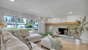 Una sala de estar moderna con chimenea, ventanas amplias y una zona de estar acogedora.