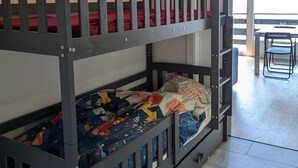 A bunk bed with a lower bunk, a small drawer, and a white cabinet above. - Cosy Apartment in a Central Location (Veysonnaz)