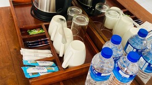 A tray with coffee makers, cups, utensils, and water bottles in a hotel room. - Hotel Sandriana Kandy (Kandy)