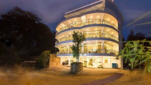 A multi-story hotel with a curved facade, multiple balconies, and a well-lit entrance. - Hotel Sandriana Kandy (Kandy)