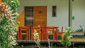 A building with a wooden door, a window, and a small outdoor seating area with chairs. - Sol Samara (Sámara)