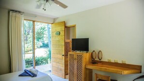 A hotel room with a bed, a desk with a television, a chair, and a view of the outdoors. - Sol Samara (Sámara)