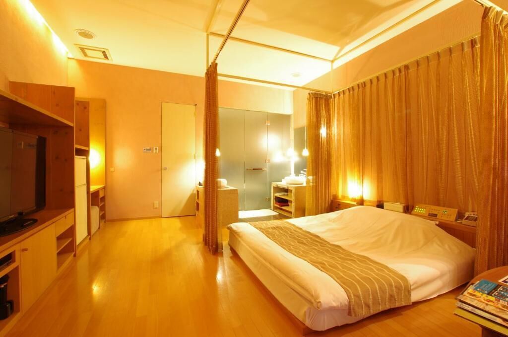 Ein Hotelzimmer mit Bett, Fernseher, Schreibtisch und Spiegel.