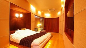 Ein Hotelzimmer mit gewölbter Decke, einem Bett mit weißen Leinen, einem Nachttisch und einem Spiegel.