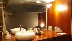 Ein Badezimmer mit zwei Waschbecken, einem Spiegel und verschiedenen Pflegeprodukten auf der Ablagefläche.