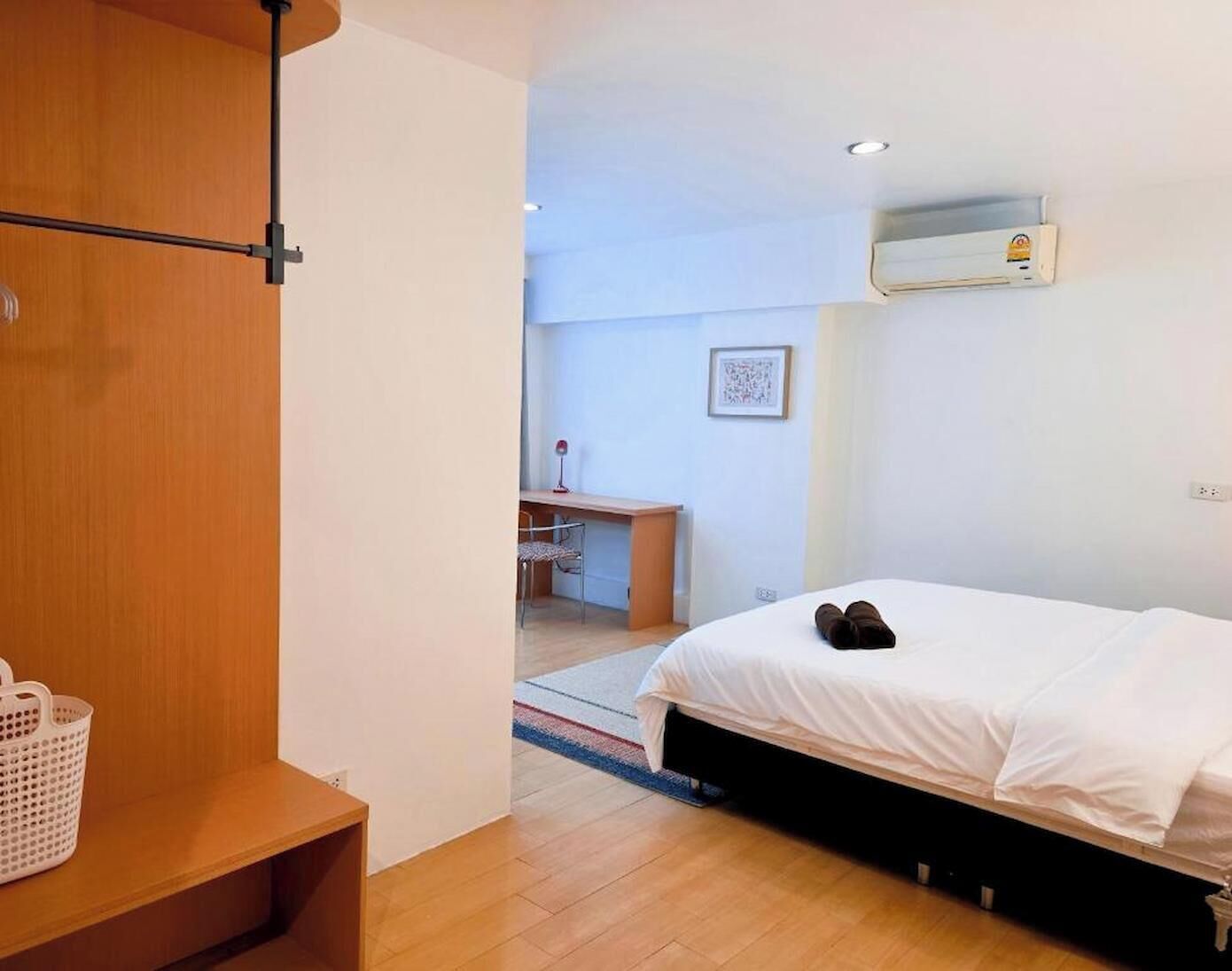 A bedroom with a bed, a desk, and a chair.