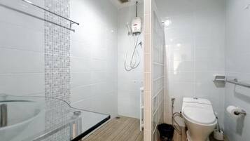 A modern bathroom with a glass shower enclosure, a toilet, and a glass sink.
