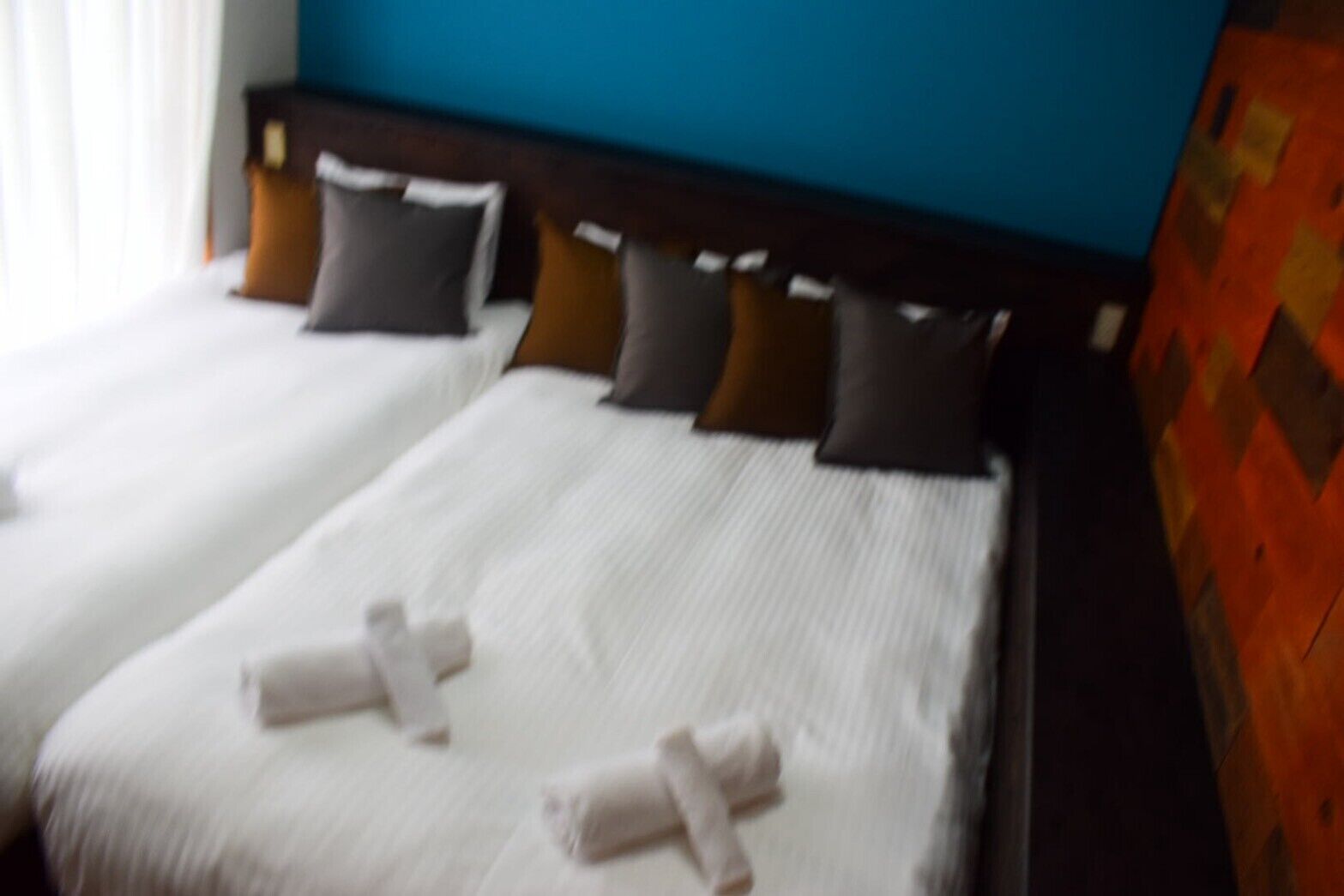 A hotel room with two beds, each with white bedding and multiple pillows.