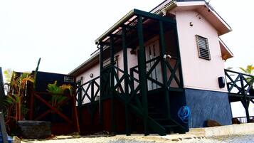 Ein Gebäude mit einem Balkon, einem Schild mit der Aufschrift '118 Terrace' und einem blauen Schlauch auf dem Boden.
