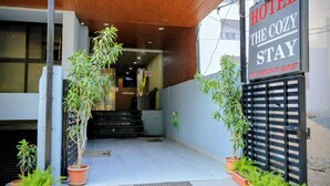 A hotel entrance with a sign reading 'HOTEL THE COZY STAY' and a focus on the entrance area. - Hotel The Cozy Stay (Indore)