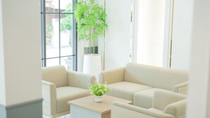 A modern living room with a beige sofa, a small table, and a potted plant. - B2 Future Park Rangsit Boutique & Budget (Thanyaburi)