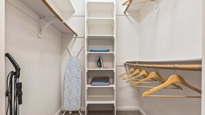 A walk-in closet with a vacuum cleaner, ironing board, and wooden hangers. - Fable 2Bd-2Ba MarinaDelRey Parking, Pool & Jacuzzi (Marina del Rey)