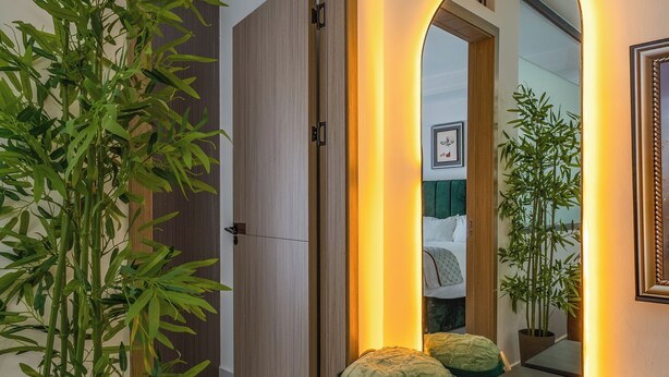 A modern interior with a potted plant, a round storage bin, and a mirror with a warm light. - Stylish, fully equipped apartment in the prime area of Westlands, Nairobi (Nairobi)