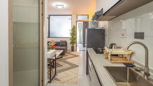 A modern kitchen with a stainless steel sink, a built-in oven, and a microwave. - Stylish, fully equipped apartment in the prime area of Westlands, Nairobi (Nairobi)