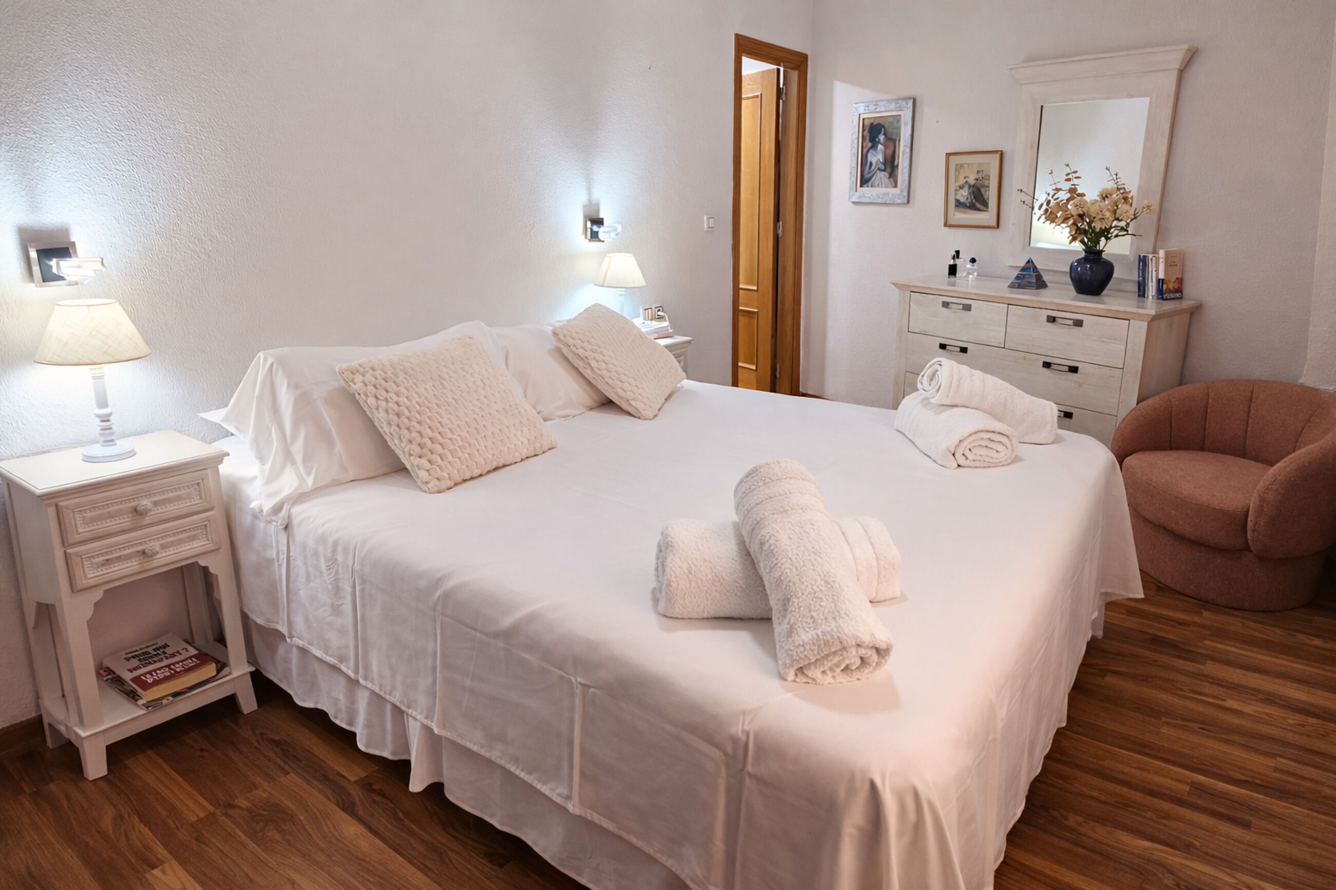 Ein ordentlich eingerichtetes Schlafzimmer mit Bett, Nachttischen, Kommode und Stuhl.