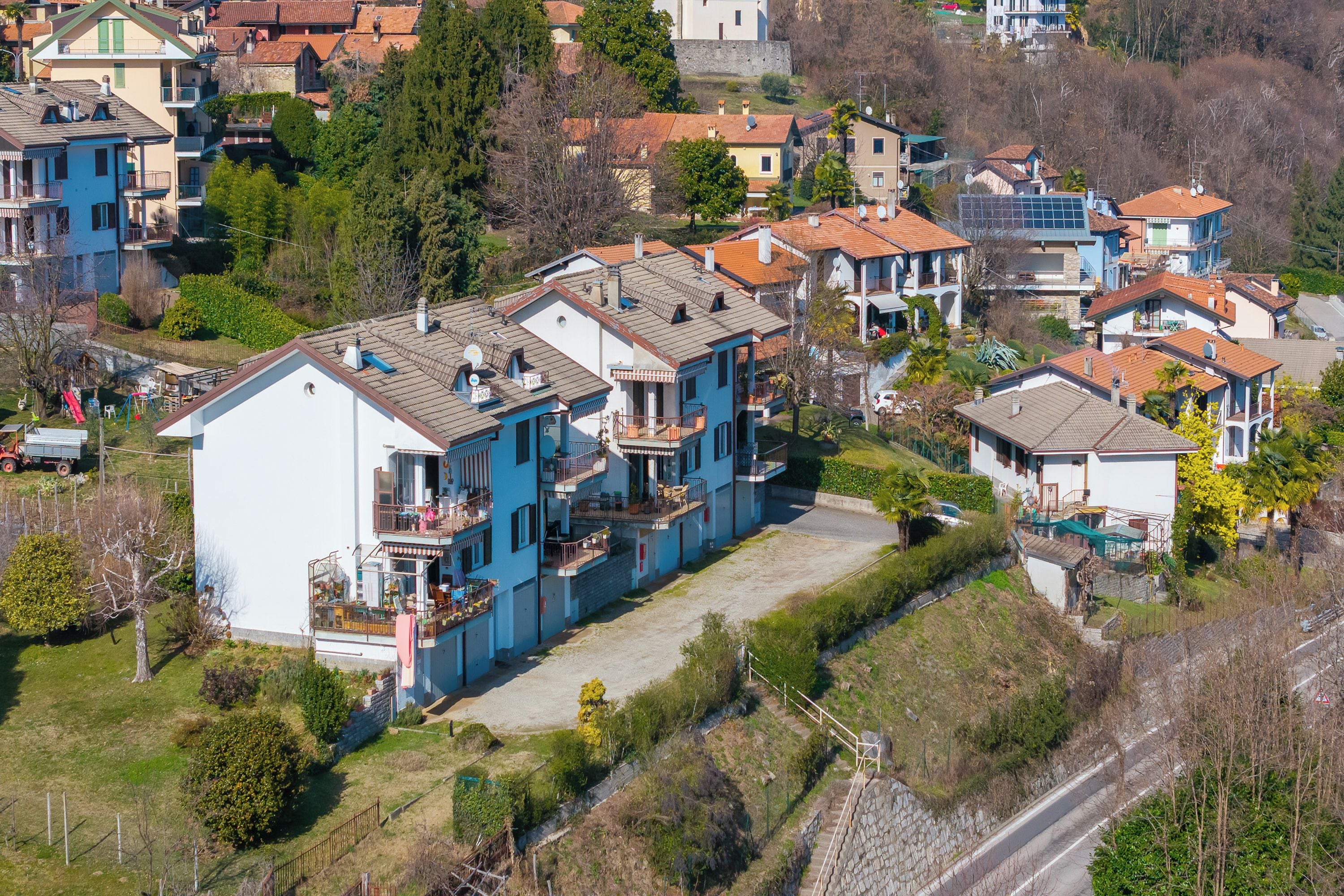 Un quartier résidentiel composé de plusieurs maisons à deux étages, avec une allée pavée et une route.