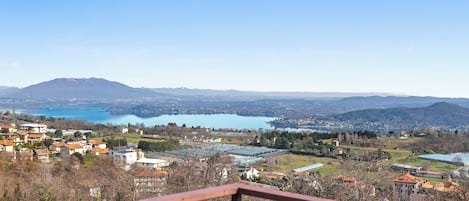 Vista panorámica de un pueblo con un lago, montañas y cielo despejado.