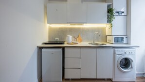 Uma cozinha compacta com máquina de lavar louça, micro-ondas e máquina de lavar roupa.