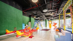 An indoor play area with a seesaw, climbing structures, and soft play surfaces. - Free Housekeeping Visits During Your Stay - Stayshort - Cozy Studio in Sposrt City That Sleeps 3 (Dubai)