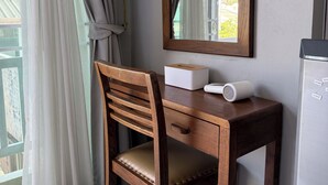 Un bureau en bois avec une chaise, un miroir, une boîte blanche et un haut-parleur.