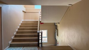Un escalier avec des marches en bois et un mur de couleur claire.