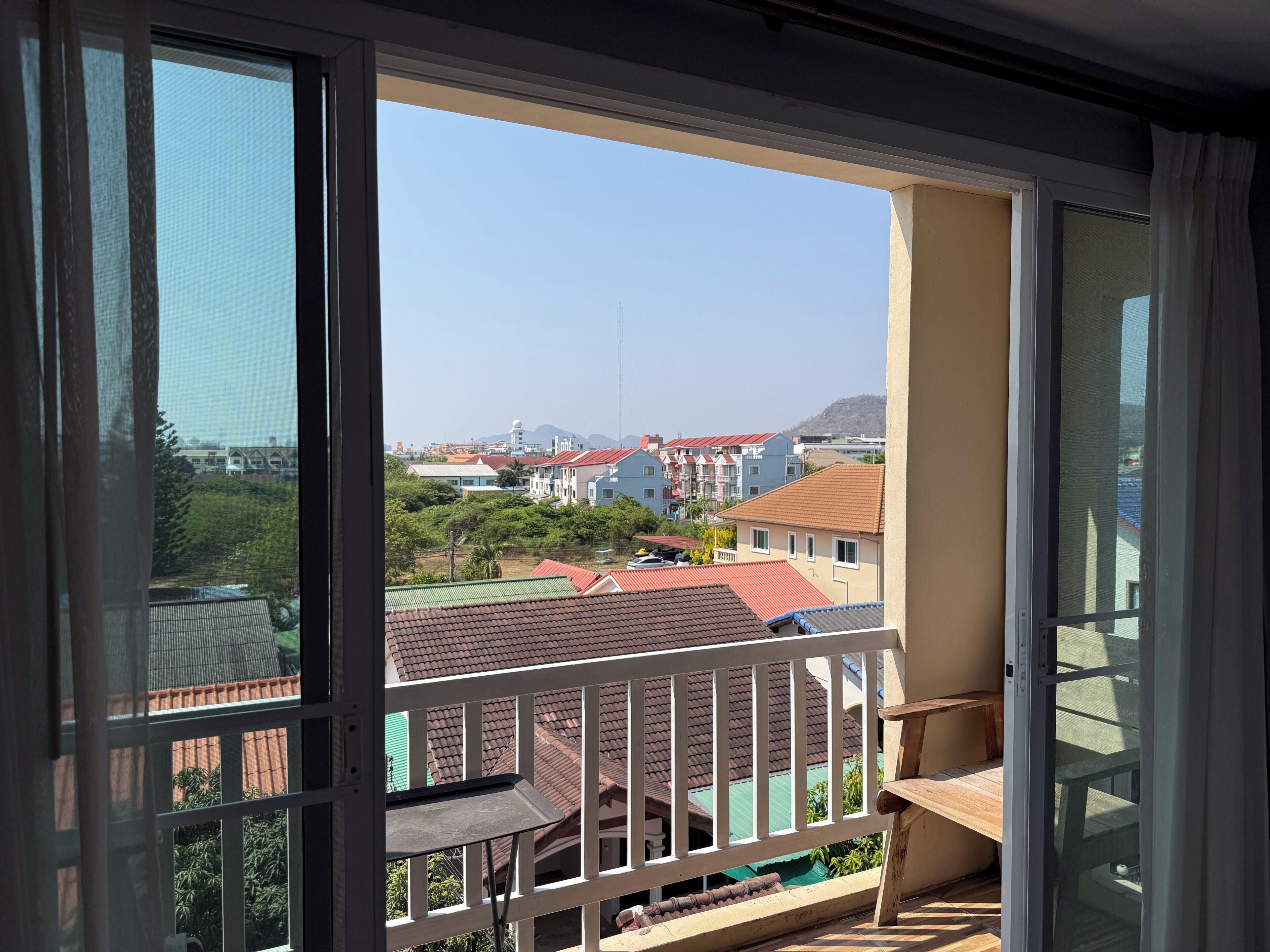 A balcony with a view of buildings and a clear sky.