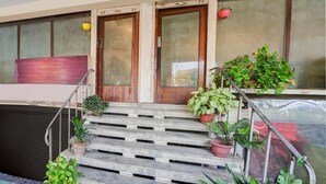 Una escalera con plantas en macetas, puertas de madera y un ventanal de vidrio.