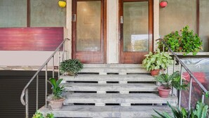 Una escalera con plantas en macetas, puertas de madera y barandilla de metal.