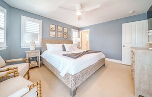 Une chambre à coucher avec un grand lit, une chaise, une table de chevet et une commode.