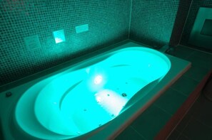 A bathtub with a blue light, tiled walls, and a visible sign. - Blue Hotel Octa (Adult Only) (Sapporo)